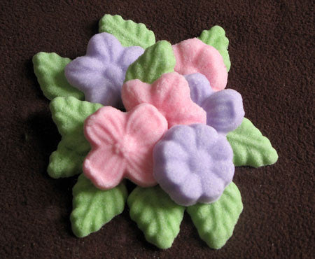 Tea sugars shaped like pink and purple flowers and green leaves